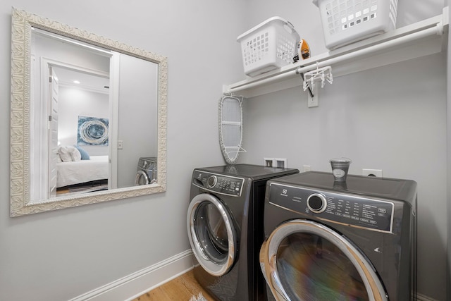 washroom featuring hardwood / wood-style floors, crown molding, hookup for a washing machine, and washing machine and clothes dryer