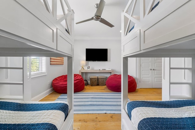 living room with light hardwood / wood-style flooring, ceiling fan, and crown molding