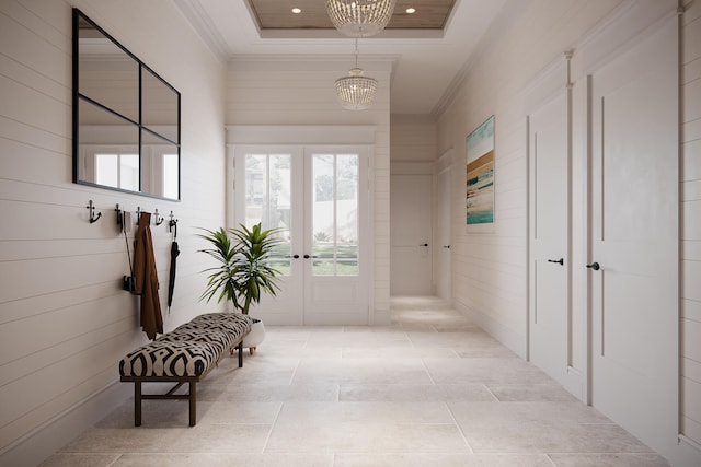 corridor with a raised ceiling, light tile floors, french doors, and a chandelier