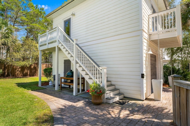 view of side of home featuring a patio and a yard