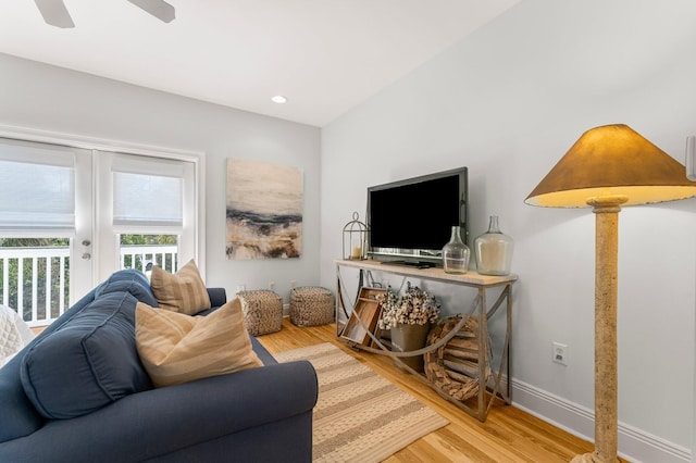 living room featuring french doors, ceiling fan, and light wood-type flooring