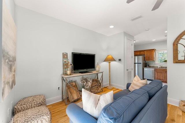 living room with ceiling fan and light wood-type flooring