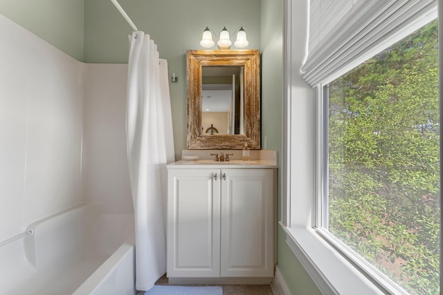 bathroom featuring vanity with extensive cabinet space and shower / tub combo