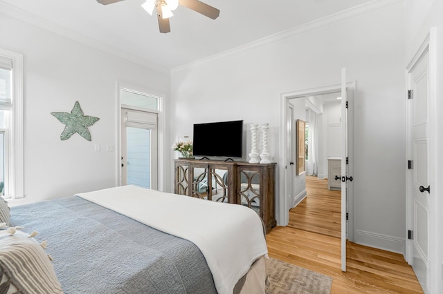 bedroom featuring ornamental molding, light hardwood / wood-style flooring, ceiling fan, and multiple windows