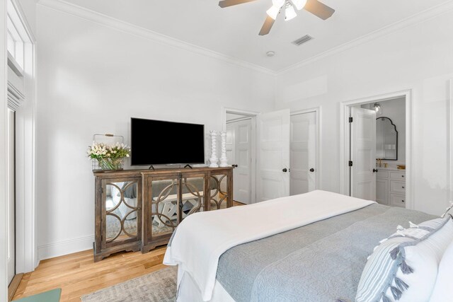 bedroom featuring multiple windows, ensuite bath, ceiling fan, light hardwood / wood-style floors, and crown molding