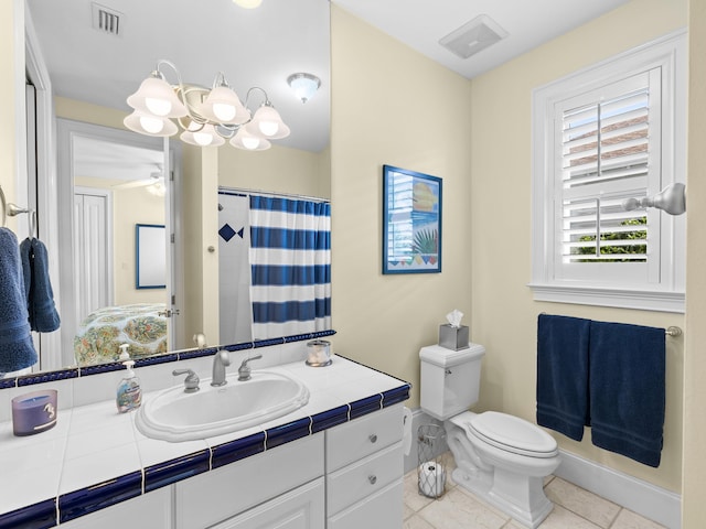 bathroom with ceiling fan with notable chandelier, toilet, tile floors, and vanity