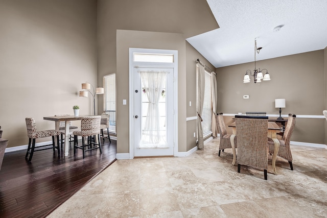 tiled dining room featuring a wealth of natural light, a chandelier, and a textured ceiling