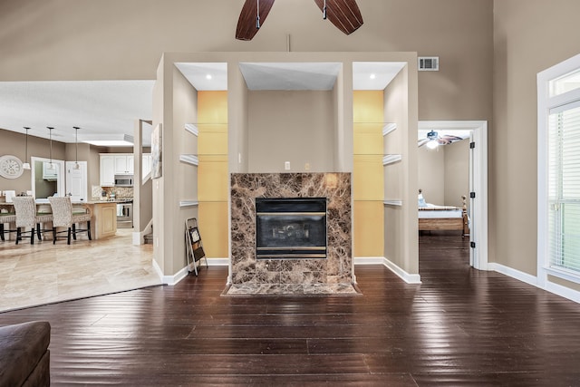 tiled living room featuring ceiling fan and a fireplace