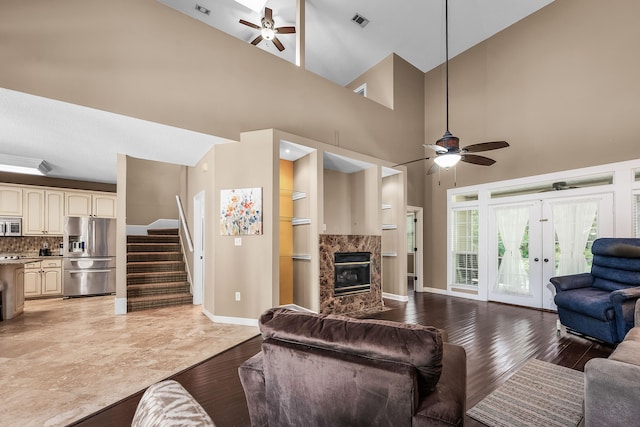 tiled living room featuring high vaulted ceiling, ceiling fan, and a fireplace