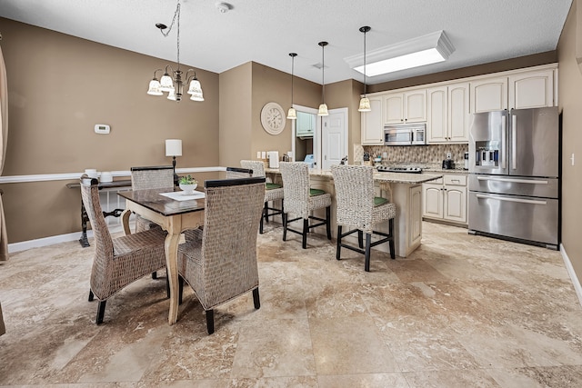 tiled dining room with an inviting chandelier and a textured ceiling