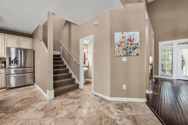 tiled foyer entrance featuring a towering ceiling and a textured ceiling