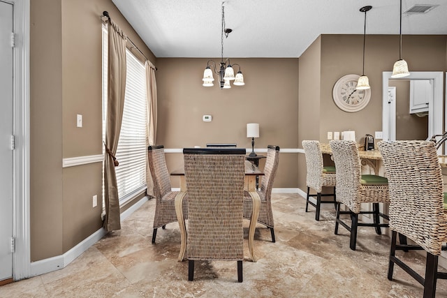 dining space with a notable chandelier, a textured ceiling, and tile floors