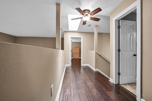 corridor featuring dark hardwood / wood-style flooring and a textured ceiling