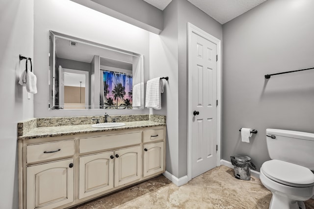 bathroom featuring tile floors, a textured ceiling, oversized vanity, and toilet