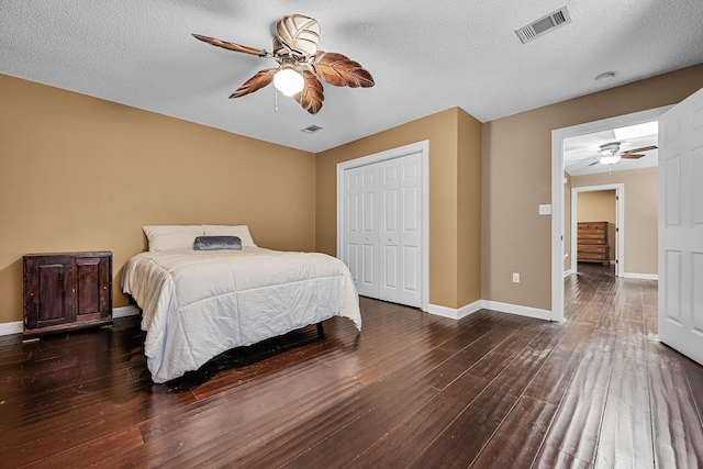 bedroom with dark hardwood / wood-style flooring, a closet, ceiling fan, and a textured ceiling