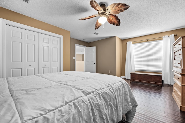 bedroom featuring a closet, ceiling fan, dark hardwood / wood-style flooring, and a textured ceiling