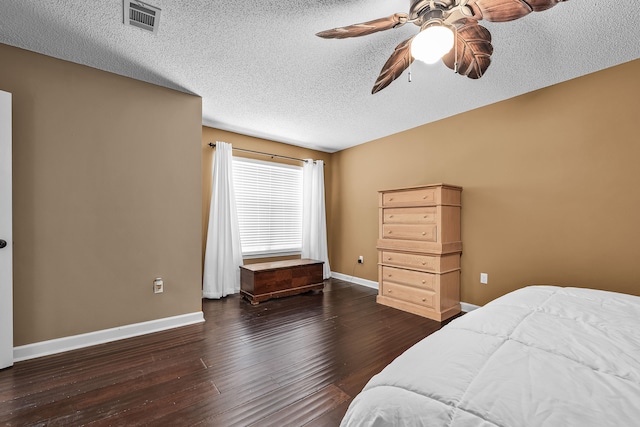 bedroom with dark wood-type flooring, ceiling fan, and a textured ceiling