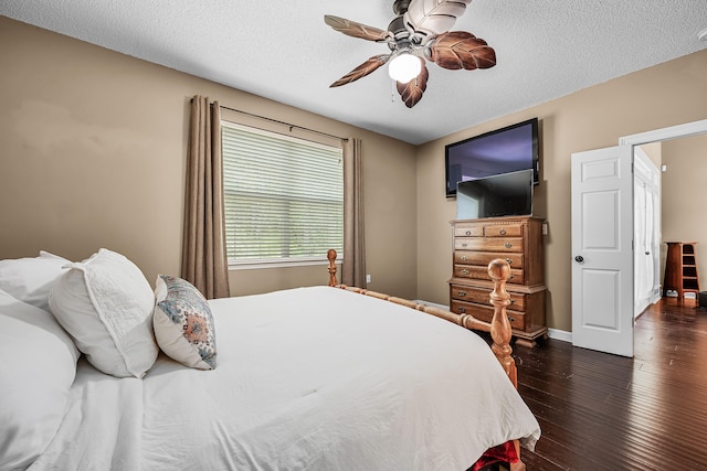 bedroom with a textured ceiling, ceiling fan, and dark hardwood / wood-style flooring