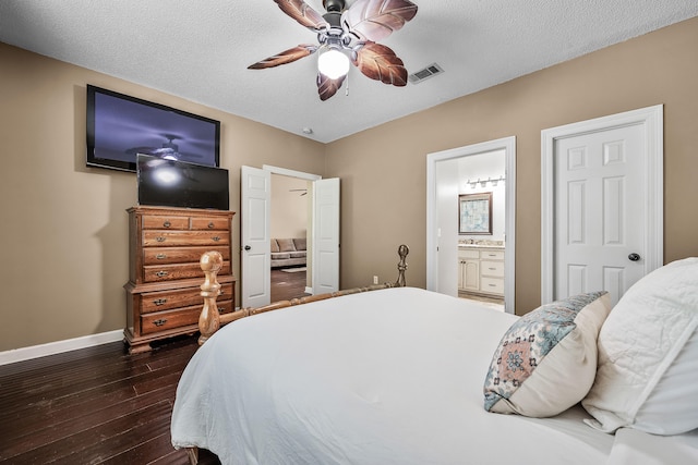 bedroom with dark hardwood / wood-style floors, ceiling fan, a textured ceiling, and connected bathroom