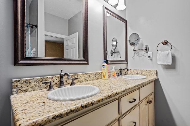 bathroom featuring dual sinks and vanity with extensive cabinet space