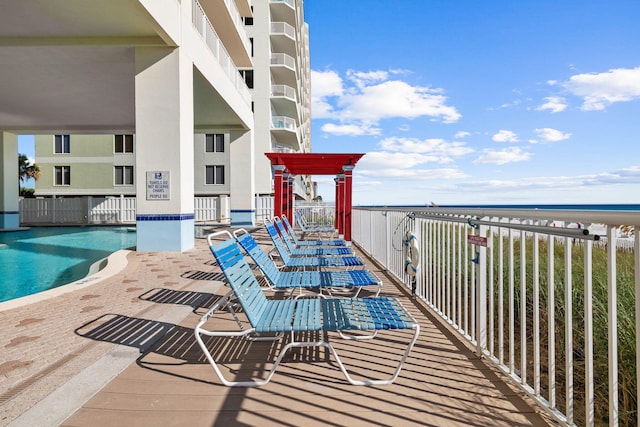 balcony with a water view and a community pool