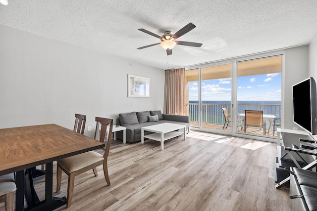 interior space featuring a water view, a textured ceiling, ceiling fan, and hardwood / wood-style flooring