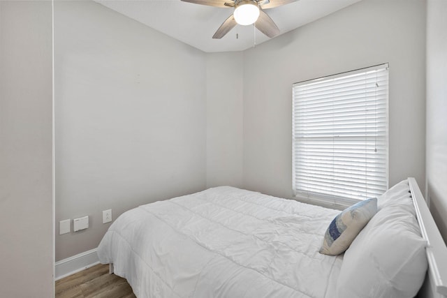 bedroom with ceiling fan, hardwood / wood-style flooring, and multiple windows