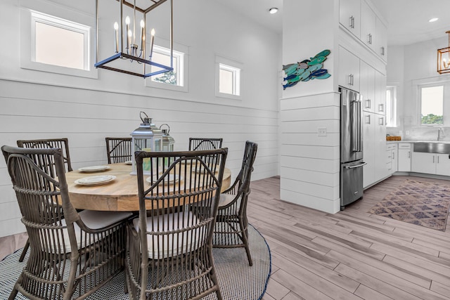 dining space with a chandelier, light hardwood / wood-style flooring, and sink