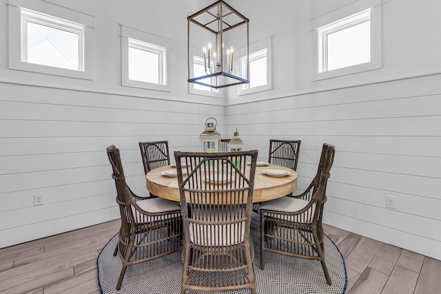 dining area with hardwood / wood-style flooring and a notable chandelier