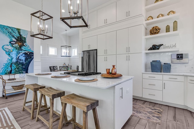 kitchen featuring appliances with stainless steel finishes, pendant lighting, a kitchen island, and white cabinetry