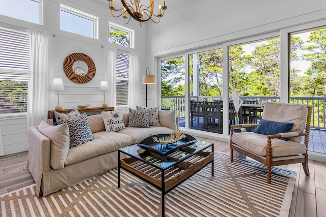 living room with hardwood / wood-style floors, a wealth of natural light, and an inviting chandelier