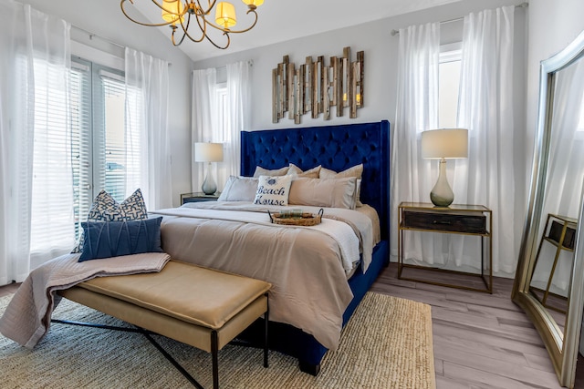 bedroom with a notable chandelier and light wood-type flooring