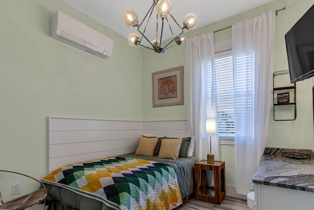 bedroom with a notable chandelier, an AC wall unit, and hardwood / wood-style flooring