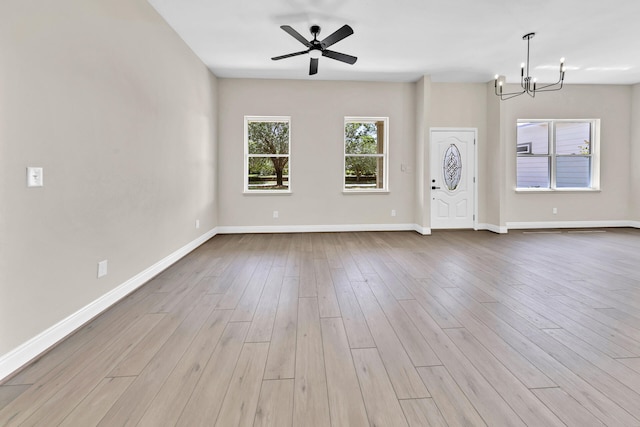 interior space featuring ceiling fan with notable chandelier and light wood-type flooring