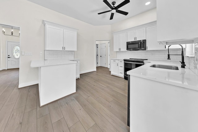 kitchen featuring light hardwood / wood-style flooring, ceiling fan, range with electric stovetop, white cabinets, and sink