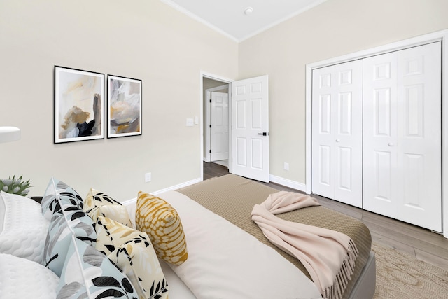 bedroom featuring a closet, hardwood / wood-style floors, and crown molding