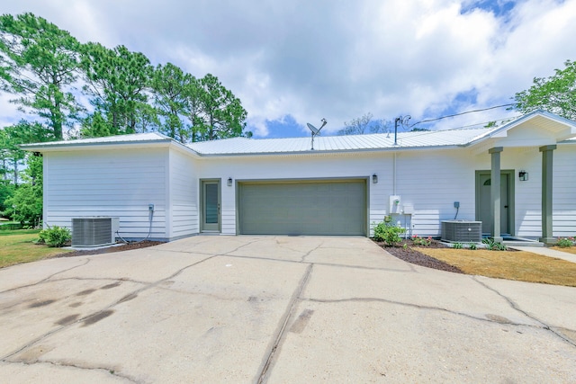 ranch-style house featuring a garage and central air condition unit