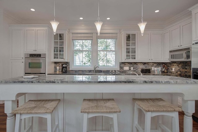 kitchen featuring backsplash, stainless steel appliances, dark wood-type flooring, light stone counters, and white cabinets