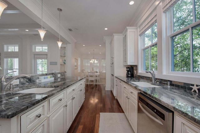 kitchen with dark wood-type flooring, dishwasher, sink, and decorative light fixtures