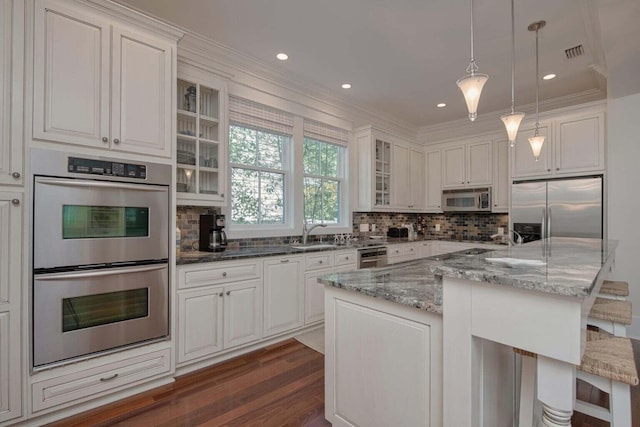 kitchen with dark hardwood / wood-style flooring, appliances with stainless steel finishes, backsplash, and white cabinetry