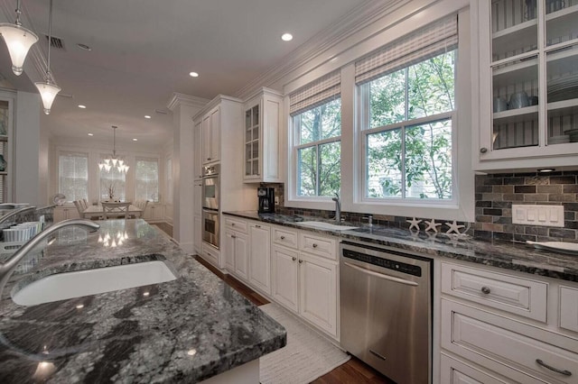 kitchen with decorative light fixtures, white cabinets, stainless steel appliances, sink, and hardwood / wood-style flooring