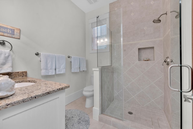 bathroom featuring tile flooring, a shower with door, vanity, and toilet