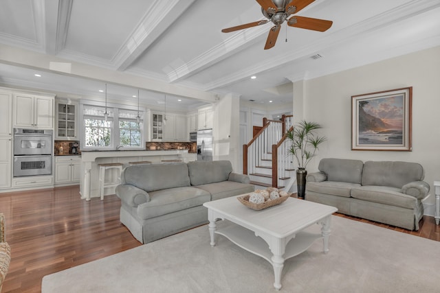 living room featuring beamed ceiling, ceiling fan, crown molding, and hardwood / wood-style flooring