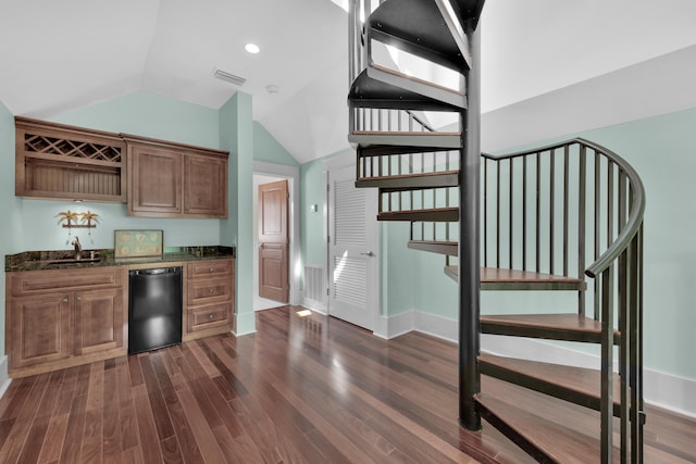 kitchen featuring high vaulted ceiling, black dishwasher, dark hardwood / wood-style floors, dark stone counters, and sink