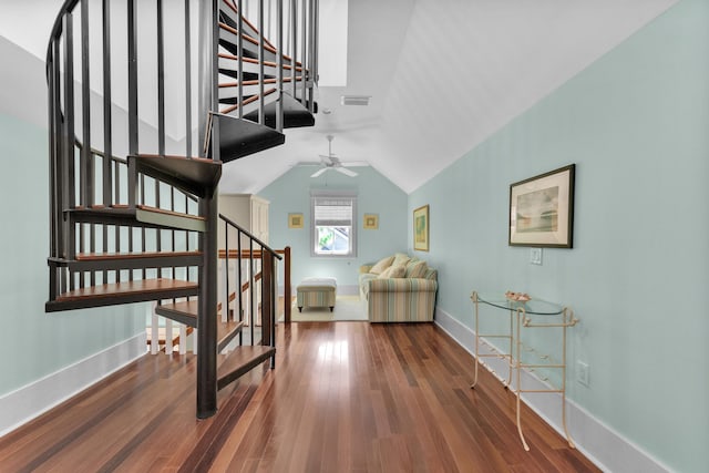 staircase featuring vaulted ceiling, hardwood / wood-style floors, and ceiling fan