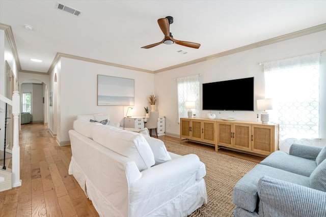 living room featuring ornamental molding, light hardwood / wood-style floors, a healthy amount of sunlight, and ceiling fan