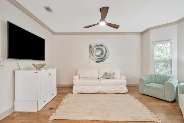 living room featuring ornamental molding, light hardwood / wood-style flooring, and ceiling fan