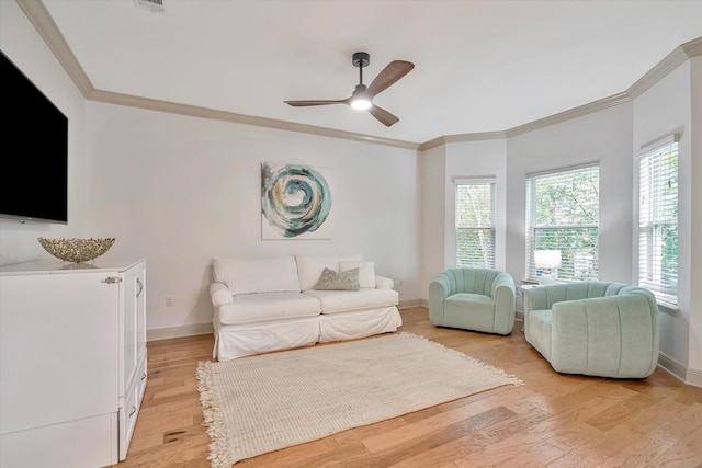 living room with ornamental molding, light hardwood / wood-style floors, and ceiling fan