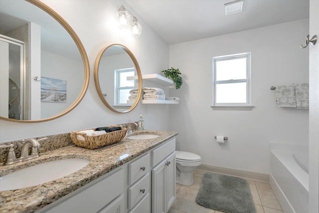 bathroom with a bath to relax in, dual bowl vanity, toilet, and tile flooring