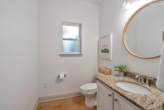 bathroom featuring hardwood / wood-style flooring, toilet, and vanity